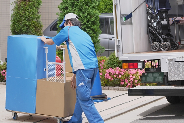 荷台で荷物を運ぶ引越しスタッフ