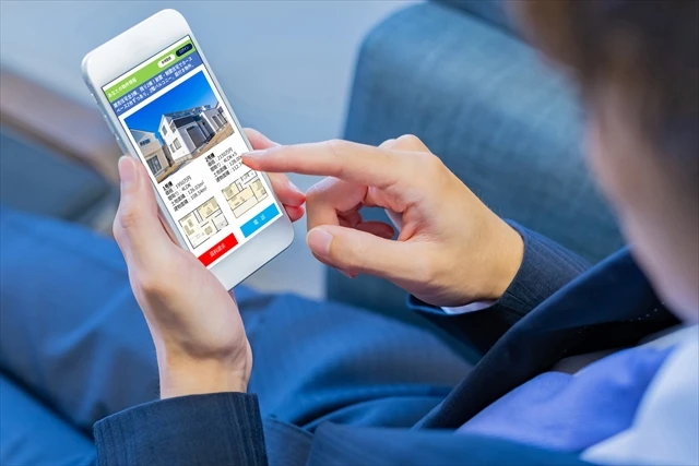 スマホで不動産のポータルサイトを見る男性